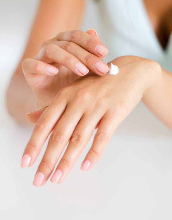 Free Woman Applying Lotion on Hand Stock Photo