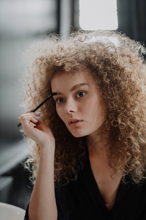 Free Woman in White Fur Coat Holding Black Pen Stock Photo