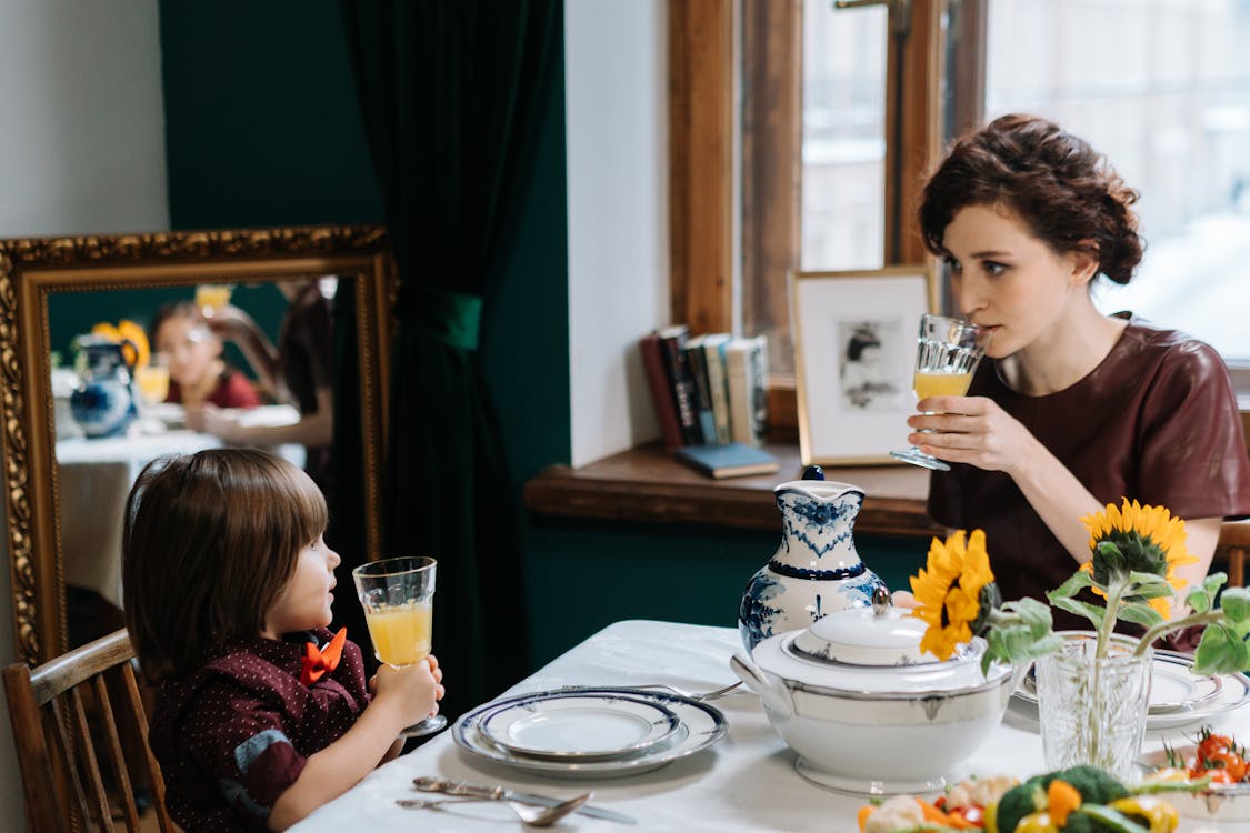 Free A Babysitter Teaching the Kid how to Properly Drink a Juice Stock Photo